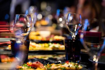 Banquet table served with glasses, food and elegant decoration for wedding or corporate event