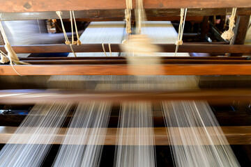 a weaving machine with a person weaving fabric on it's sides and a person standing in the background