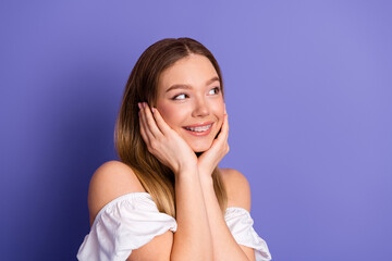 Fototapeta premium Lovely young woman with braces in stylish outfit expressing happiness against cheerful purple background