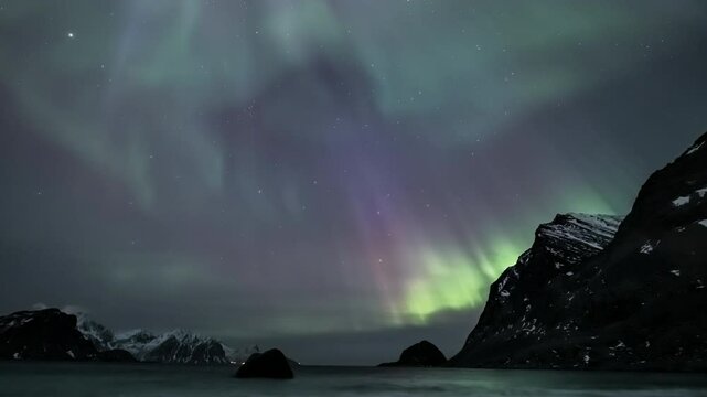 Full-sky auroras at Haukland Beach in Lofoten, Norway - slow tilt up