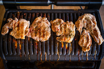 Pork steak being grilled on an electric grill, close-up