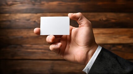 Person Holding a Blank White Card in Hand Against Wooden Background Presentation for Marketing and Branding Elegant and Professional