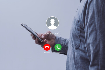 Notification of an incoming call on a smartphone held by a man wearing a shirt. Concept of mobile communication, telecommunication and incoming call notification.