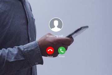 Notification of an incoming call on a smartphone held by a man wearing a shirt. Concept of mobile communication, telecommunication and incoming call notification.