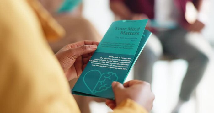 Therapy group, mental health and hands of person with pamphlet for information on stress management. Psychologist, counseling session and booklet for research on depression, anxiety or healing.