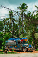 Jeepney jeep filipino colorful bus vehicle truck along tropical road with palm trees and sunny sky...