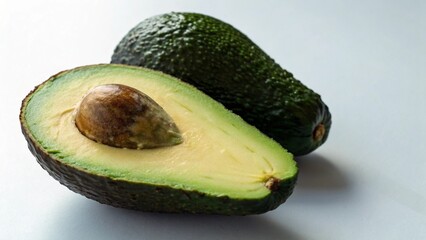 A ripe avocado is cut in half, revealing its creamy green flesh and large seed