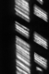 Abstract background, the shadow of a window frame cast on a dark surface. The strong contrast.