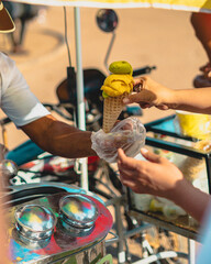Ice cream man in old fashioned stand serving a refreshing and delicious ice cone in a sunny...