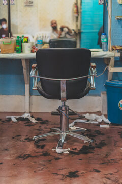 Messy hair salon barbershop with shoeless client among cut hair in Coron Town, Philippines