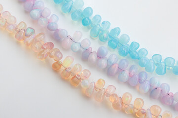 Colorful Opal Beads in Soft Pastel Shades on White Background