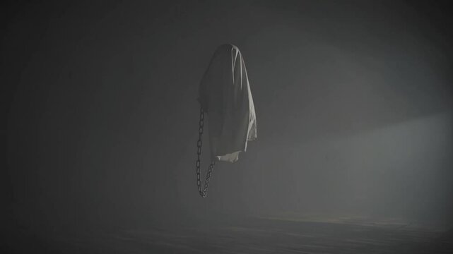 Ghost made of worn sheet and chains haunts against a professional limbo background.