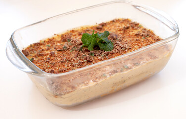 Traditional South African fridge tart in a glass dish with mint leaves and isolated on white