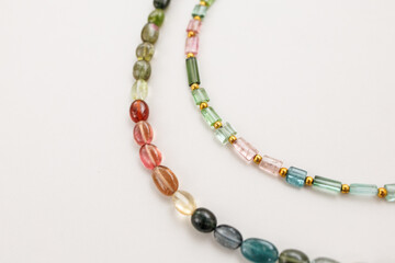 Colorful Tourmaline Beads in Mixed Shapes and Shades on a Light Background

