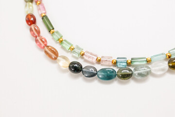Colorful Tourmaline Beads in Mixed Shapes and Shades on a Light Background


