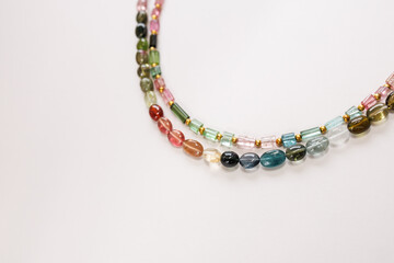 Colorful Tourmaline Beads in Mixed Shapes and Shades on a Light Background

