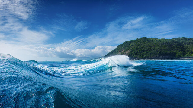 Powerful ocean wave curling with white spray across bright blue sea, capturing nature’s rhythm and tropical freedom under clear sky