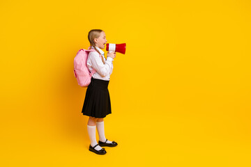 Young student with blond hair holding a megaphone and expressing messages, standing against a...
