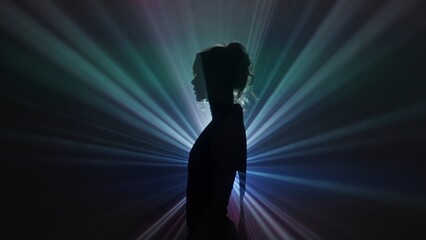 Silhouette of woman in rainbow light burst