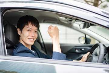 車に乗ってガッツポーズをする男性