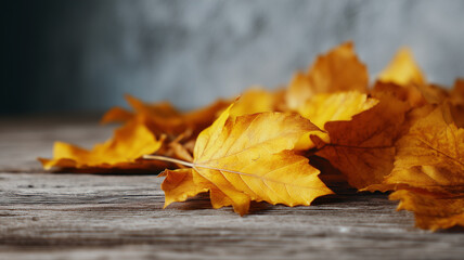 Golden autumn leaves scattered on rustic wooden table, warm seasonal atmosphere, nature background