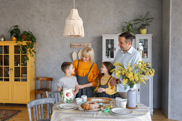 A big friendly family: dad, mom, son and daughter are cooking together in the kitchen