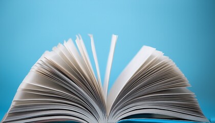 an open book with pages fanned out against a light blue background