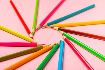 Colored pencils on a bright colored background. Equipment for coloring. Stationery for...