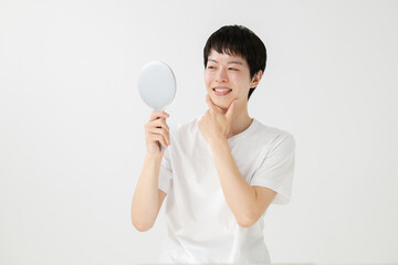 鏡を見て微笑む男性