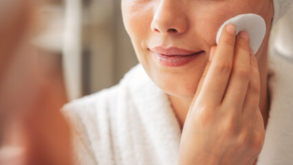 Woman cleaning skin with cotton pad