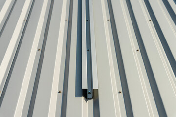 Vue sur une façade en tôle crème équipée de supports métalliques prêts à accueillir des...