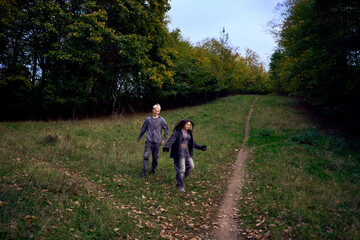 Obraz premium two 15-year-old teenagers in love play, hug, spend time together in an autumn park