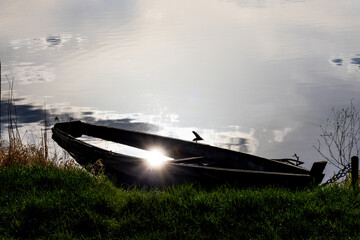 Abandoned old half-submerged wooden Boat at Sunset