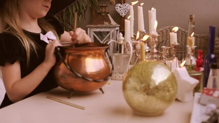 little girl in costumes stir potion in cauldron during fun Halloween play at home, casting spells, mixing potion in cauldron, young witch Halloween party atmosphere, time play witches