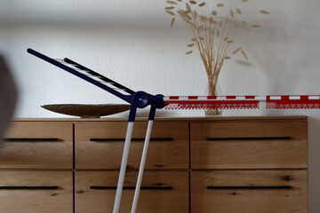 In a modernly furnished household, an empty clothes rack stands in front of a wooden sideboard
