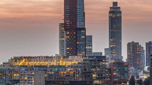 Aerial day to night transition timelapse of Katendrecht peninsula and Maashaven harbour in Rotterdam, The Netherlands. City skyline modern skyscrapers and traditional Dutch waterfront houses