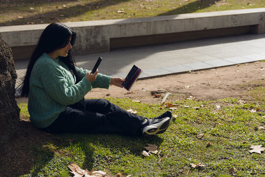 woman in the square taking a photo with her phone of the book cover