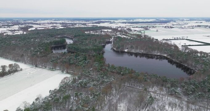 Aerial view of forest and fish pond in snow, De Witte Bergen, Asten. Netherlands