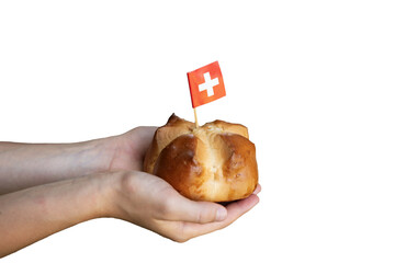 Child hands holding a national august bread bun with a swiss flag on isolated background