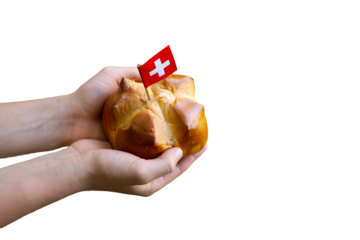 Child hands holding a national august bread bun with a swiss flag on isolated background with copy space