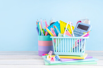 Back to school sale and shopping concept. Variety of school stationery in shopping basket pencils,...