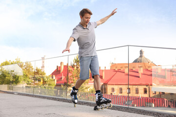 Happy man roller skating on city street