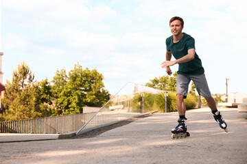 Obraz premium Happy man roller skating on city street. Space for text