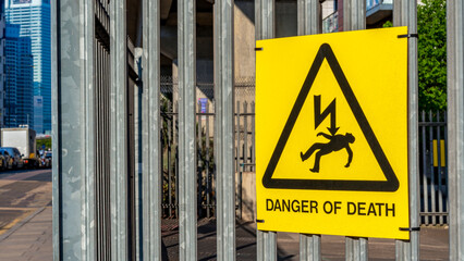 Yellow “Danger of Death” sign fixed to metal gate