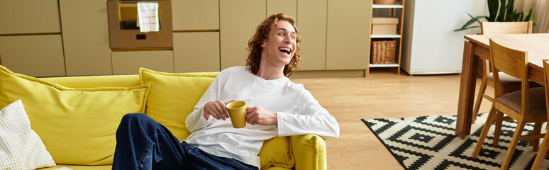 Handsome young man relaxes at home enjoying a cozy moment with a cup in hand