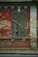Old wooden window in a red brick wall of an old house
