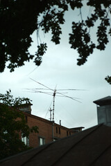 Old big antenna on the roof of a brick house against the sky, in the city