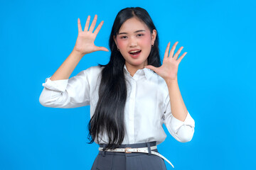 Portrait of a cheerful young Asian woman smiling and showing ten fingers enthusiastically. She...