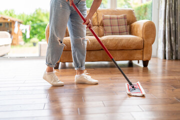 Cleaning hardwood floors in a cozy living room during a sunny afternoon with natural light...