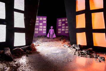 Conceptual image of a man carrying shopping bags walking on a dirt and rock-covered path through a...